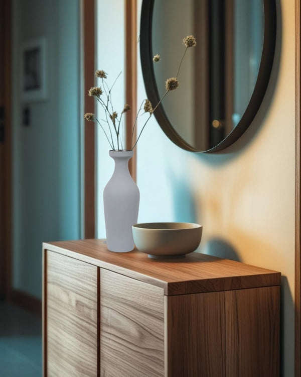 Wooden sideboard with a gray vase and bowl on top, featuring a round mirror above.