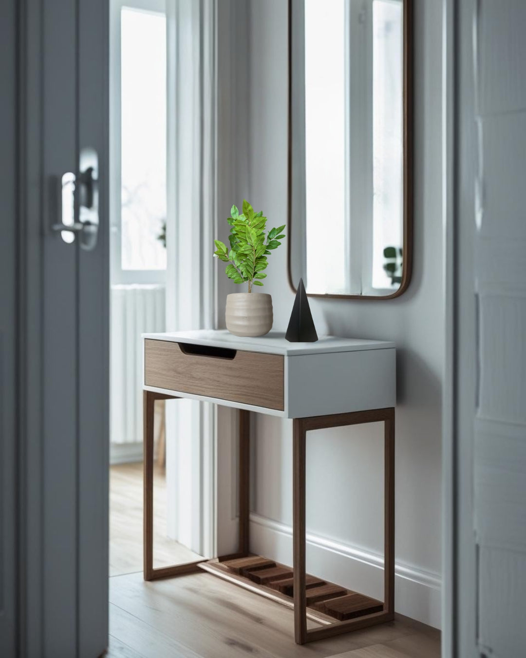 Small entry table with a drawer, plant, and mirror in a room.