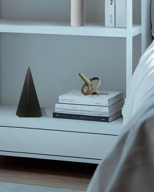 gray decorative acccent on a bookcase with books and sculptures