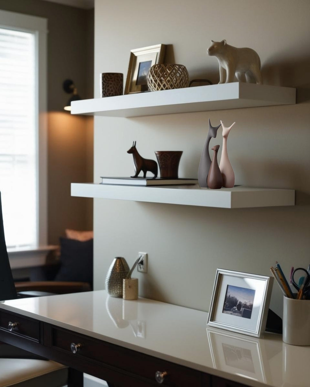 Animal-shaped decorative accents on white floating shelf and dark wood desk in farmhouse home office