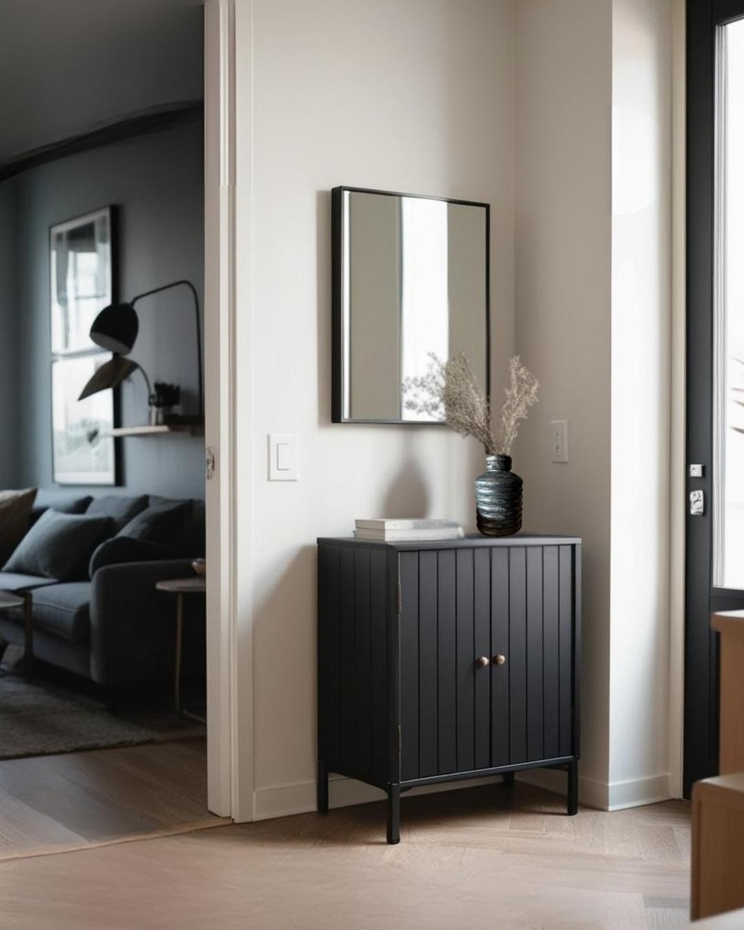 Black entry table with a wooden vase in a compact scandinavian entry in a house