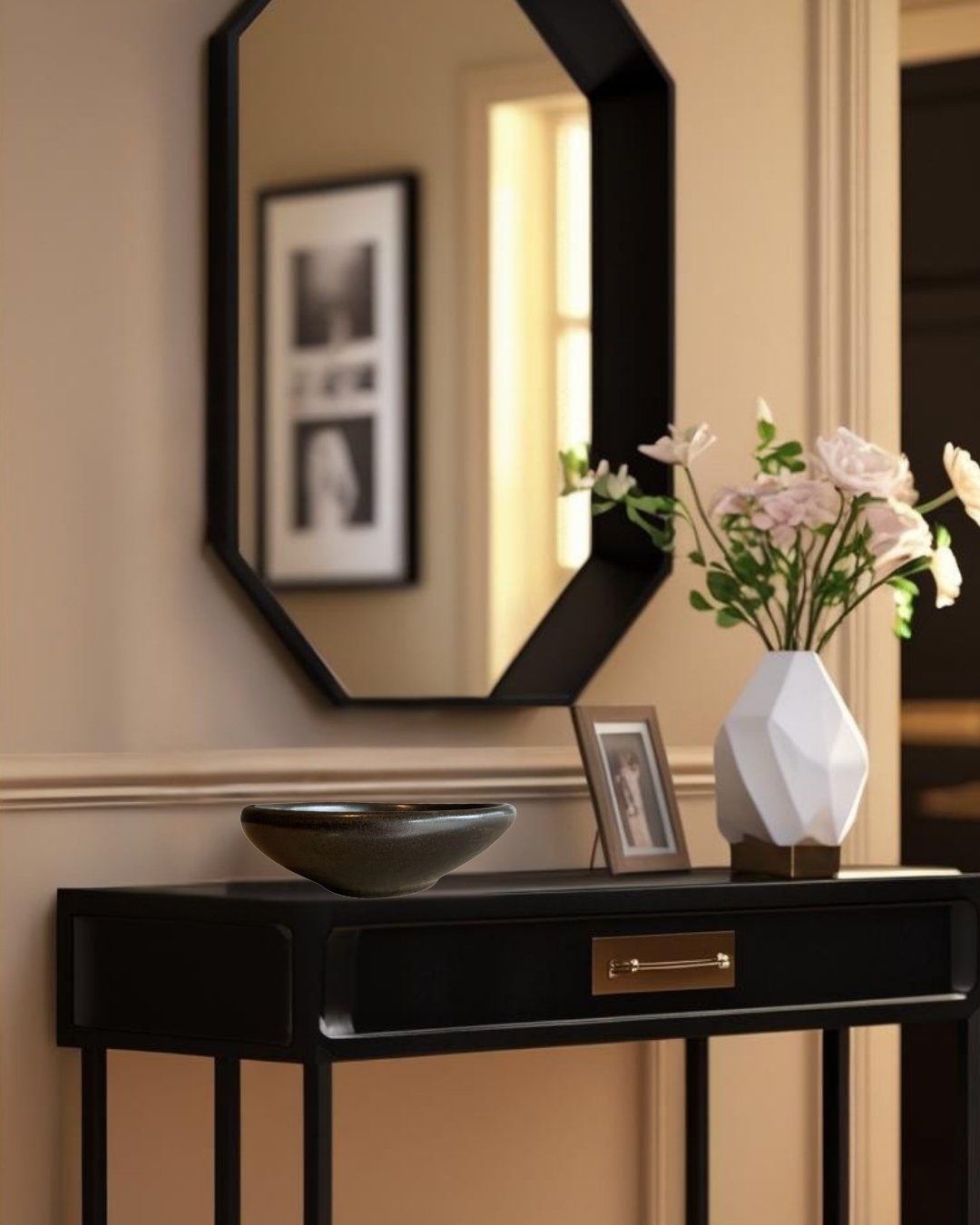 Black sculptural porcelain bowl on entry table with ceramic vase in a minimalist Scandinavian style entryway