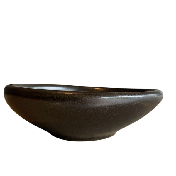Side view of bold black sculptural porcelain decorative bowl isolated on white background