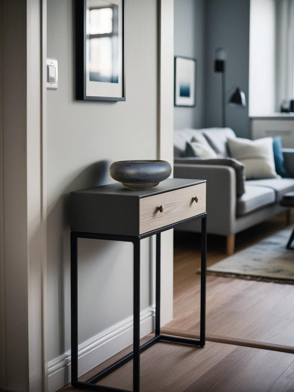Bold black rustic wooden bowl on a narrow black entry table in a Scandinavian style hallway with neutral decor