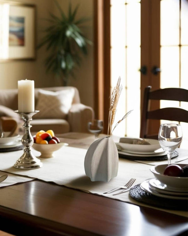 Bold sculptural geometric white vase on dining table in a farmhouse style living room