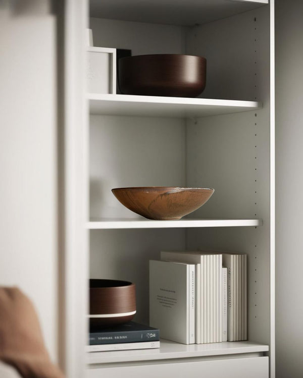 Brown porcelain bowl on a white shelf in a neutral-toned farmhouse living room