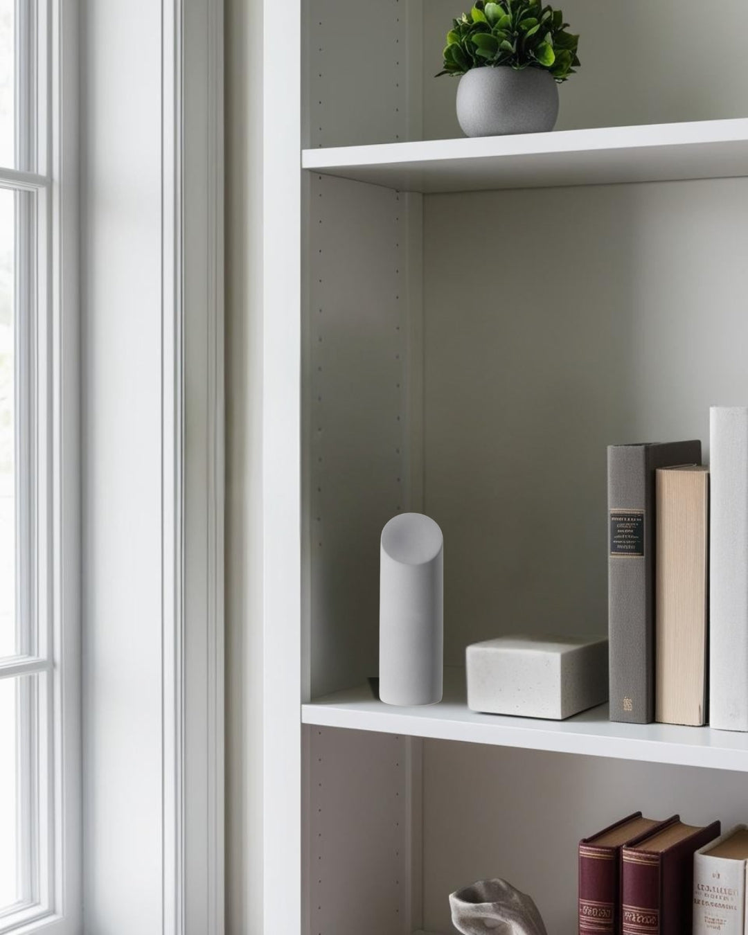  Geometric decorative accents in white finish on shelf near window in bright farmhouse bedroom