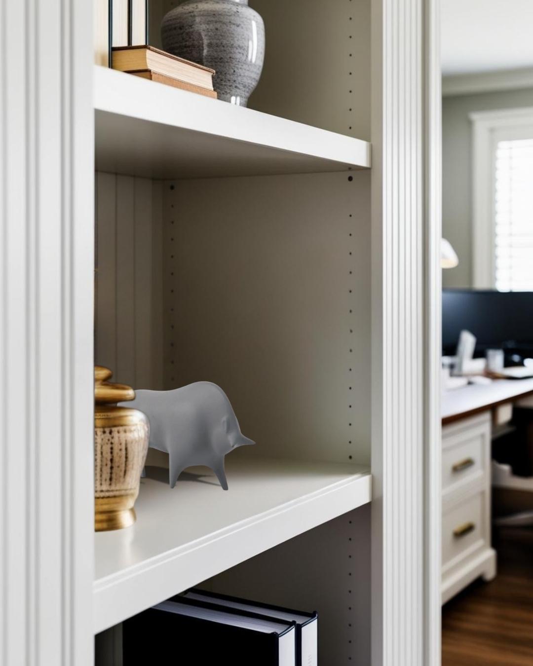 Gray concrete bull decor on bookcase in a Japandi style home office