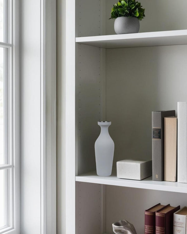 Gray sculptural ceramic vase on a white shlef in a minimalist home office