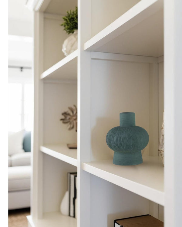 green small vase on bookcase in a coastal living room


