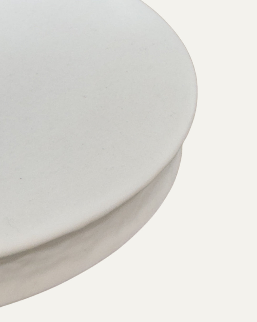 Detalle en ángulo de la superficie lisa y el borde curvo del plato blanco para postres Luxemburgo.