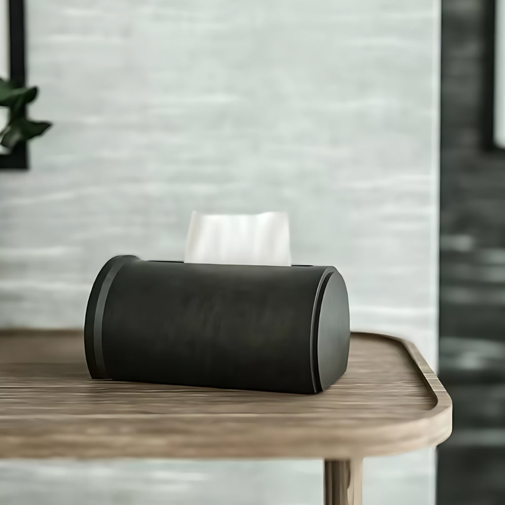 Nnordic minimalist black concrete tissue box with a modern cylindrical design, placed on a bathroom counter.