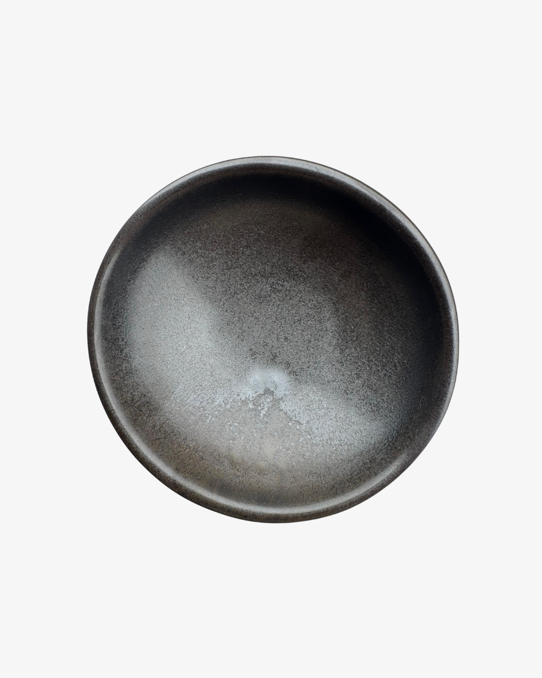 Plato Halvsirkel oscuro con interior moteado y borde ligeramente irregular, visto desde arriba sobre fondo blanco.