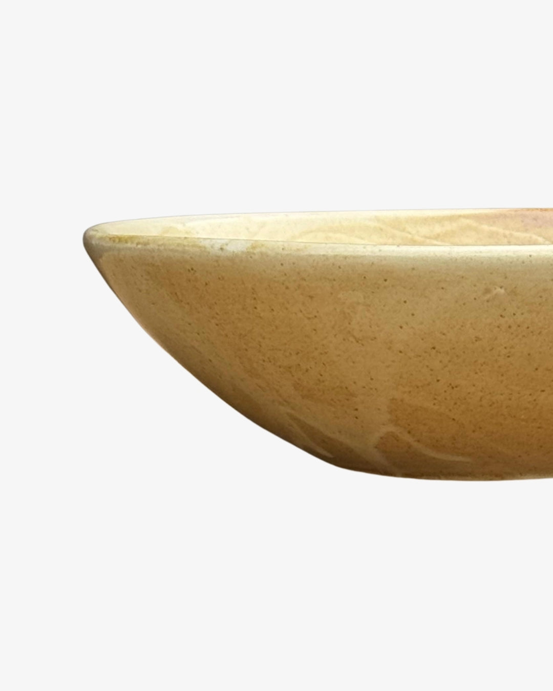 Detalle del borde claro y las paredes curvas del plato hondo Dobbelt beige, con pequeñas motas marrones.