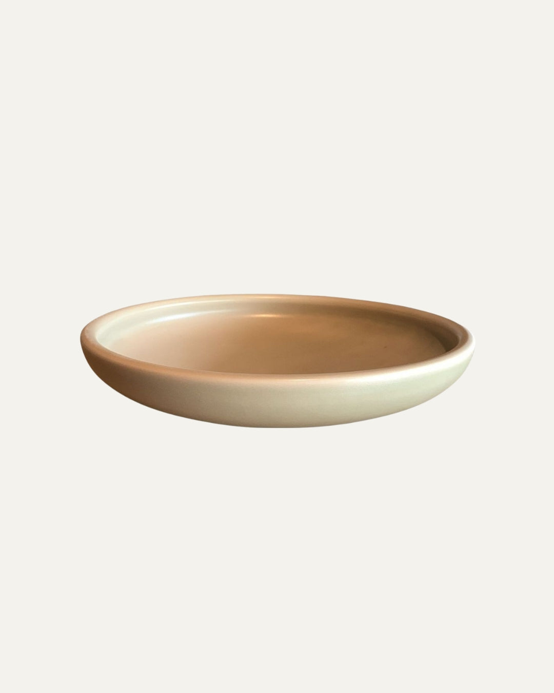 Plato hondo Traktskal beige salvia de forma redonda, con interior liso y borde curvo, visto en ángulo lateral sobre blanco.