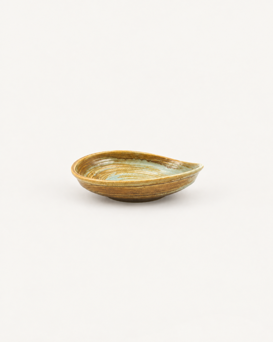 Plato hondo Ocaso ámbar y crema con anillos y paredes curvas, visto de lado sobre fondo blanco.