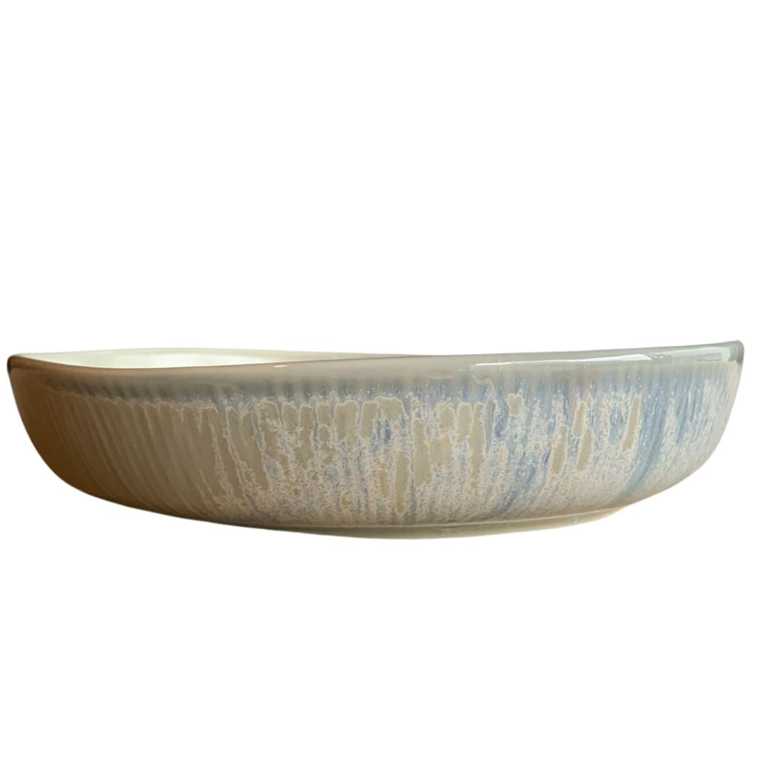 Rustic blue shallow porcelain bowl side view on white background
