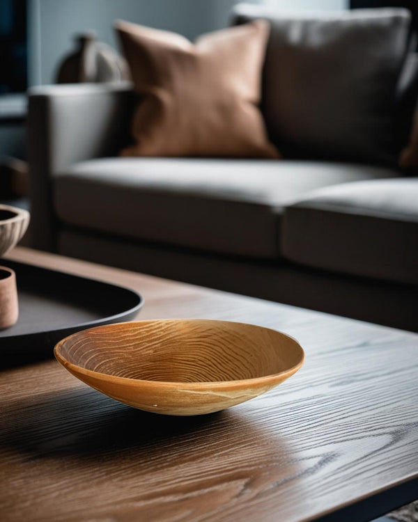 Rustic brown porcelain bowl with reactive glaze on a dark wood coffee table in a Scandinavian style living room with neutral sofa