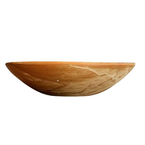 Side view of rustic brown porcelain bowl with reactive glaze isolated on white background