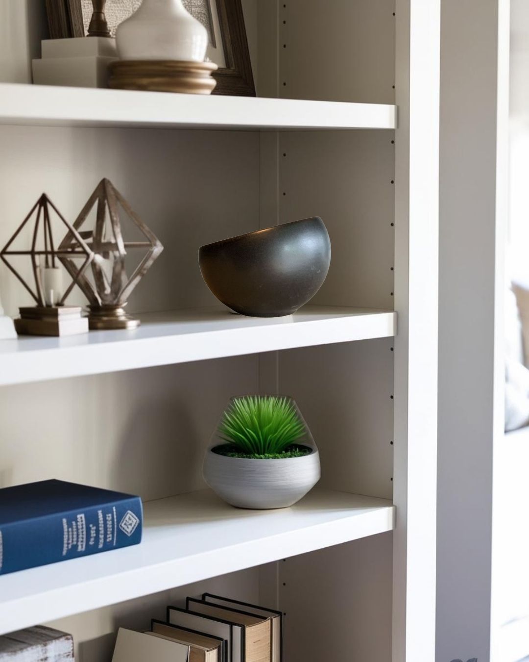 Sculptural porcelain bowl on a white bookcase in a rustic-modern room with decorative accents and neutral lighting