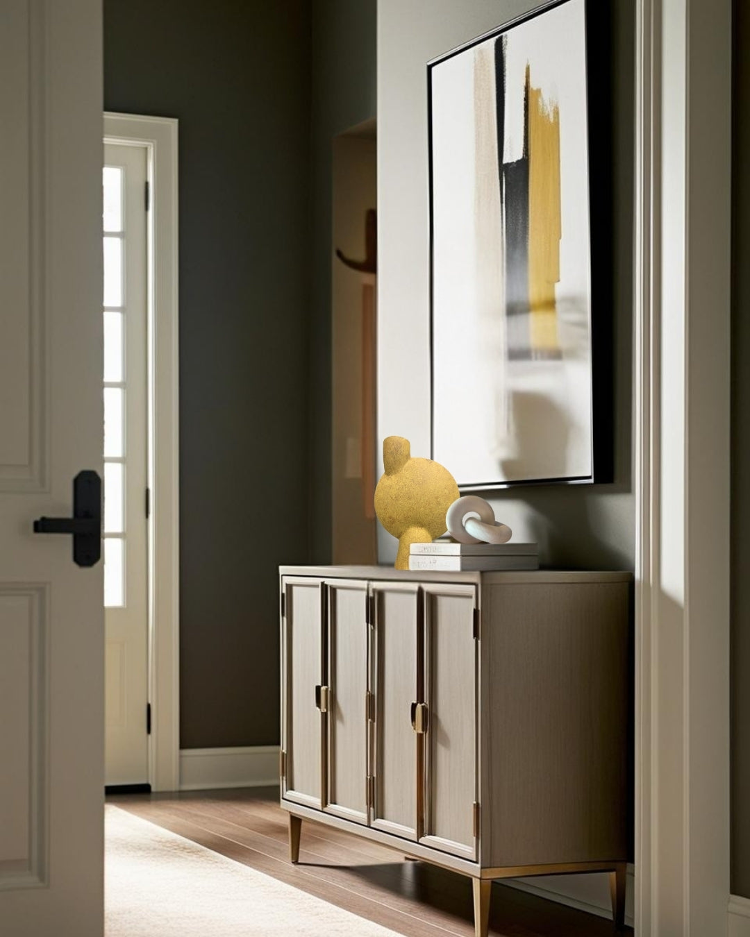 Sculptural ochre yellow vase on a entry table in a minimalist entry