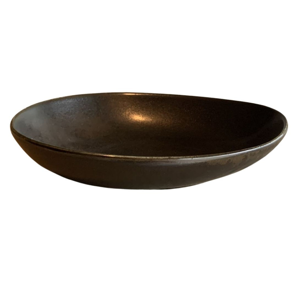 Top view of shallow black sculptural porcelain decorative bowl isolated on white background