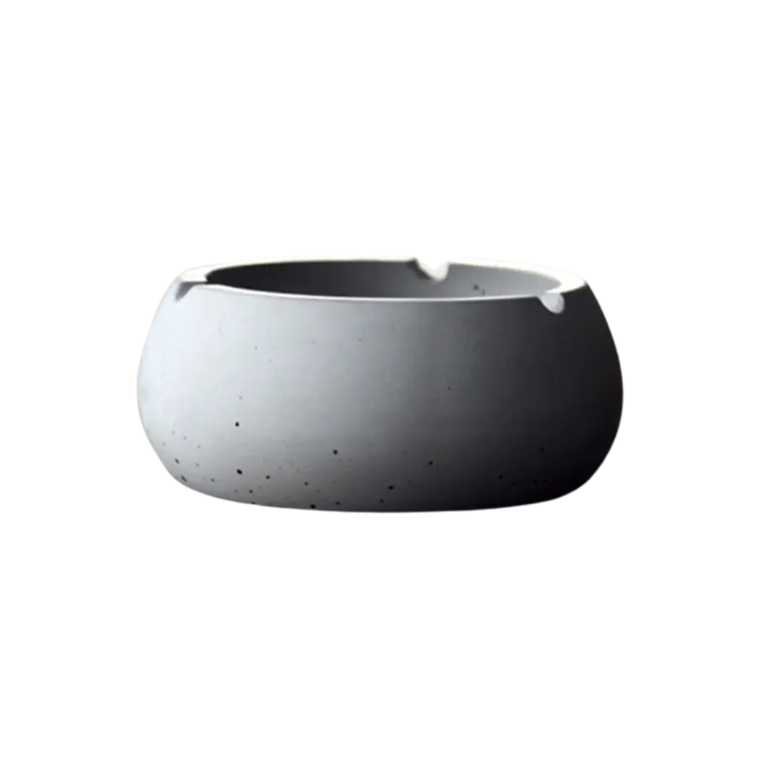 Side view of minimalist concrete ashtray with dark base, isolated on white background