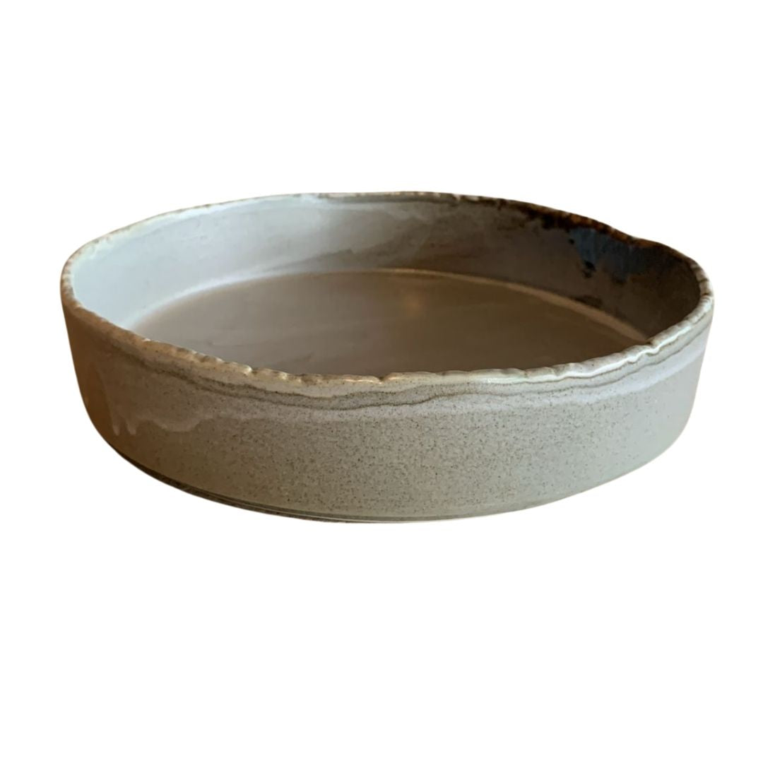 Top view of striped shallow decorative porcelain bowl in beige and white, isolated on white background