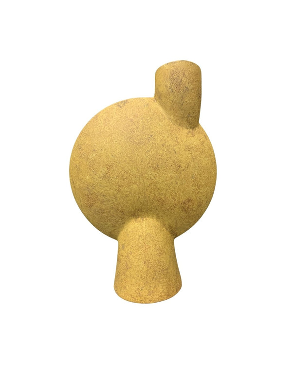 white background of a tall sculptural vase in ochre yellow with a unique geometric shape