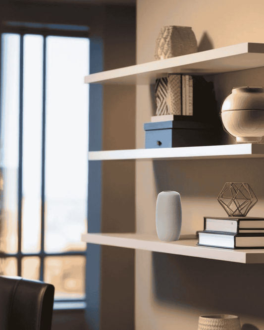 White ceramic vase on floating shelf in a compact Scandinavian home office

