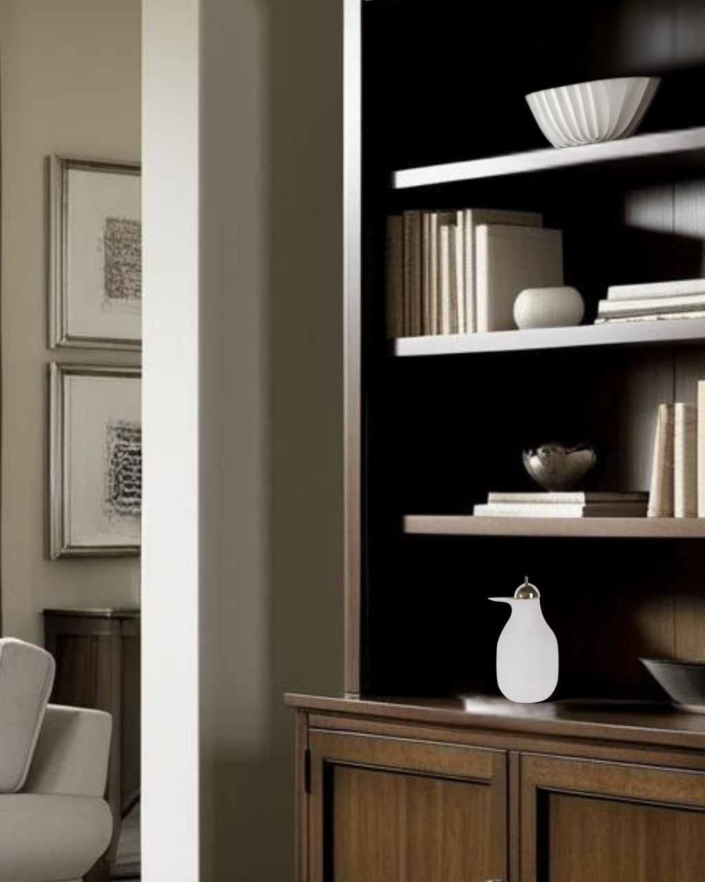 White decorative pitcher on dark wood bookcase in farmhouse style living room