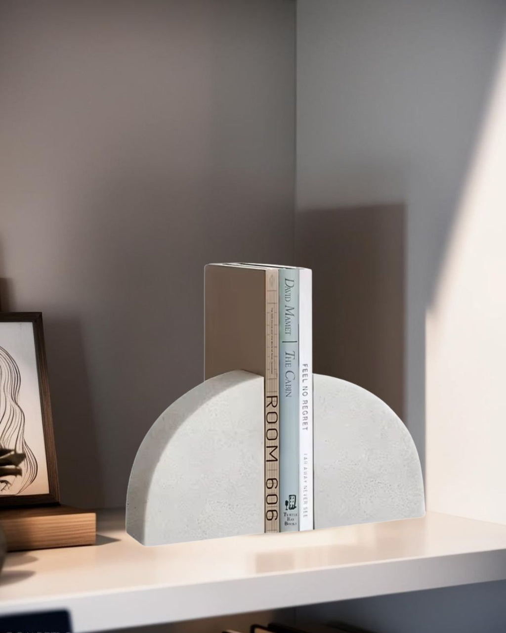 White half-circle modern bookend holding books on shelf, styled with minimalist artwork and contemporary decor in natural light