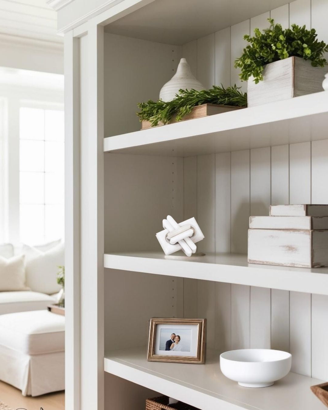 White knot sculpture on farmhouse bookshelf in living room