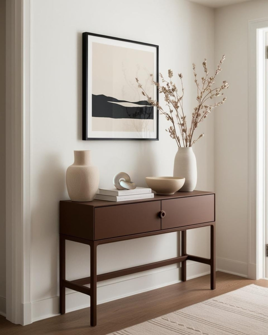 White knot-shaped sculpture on dark wood entry table in minimalist farmhouse entry
