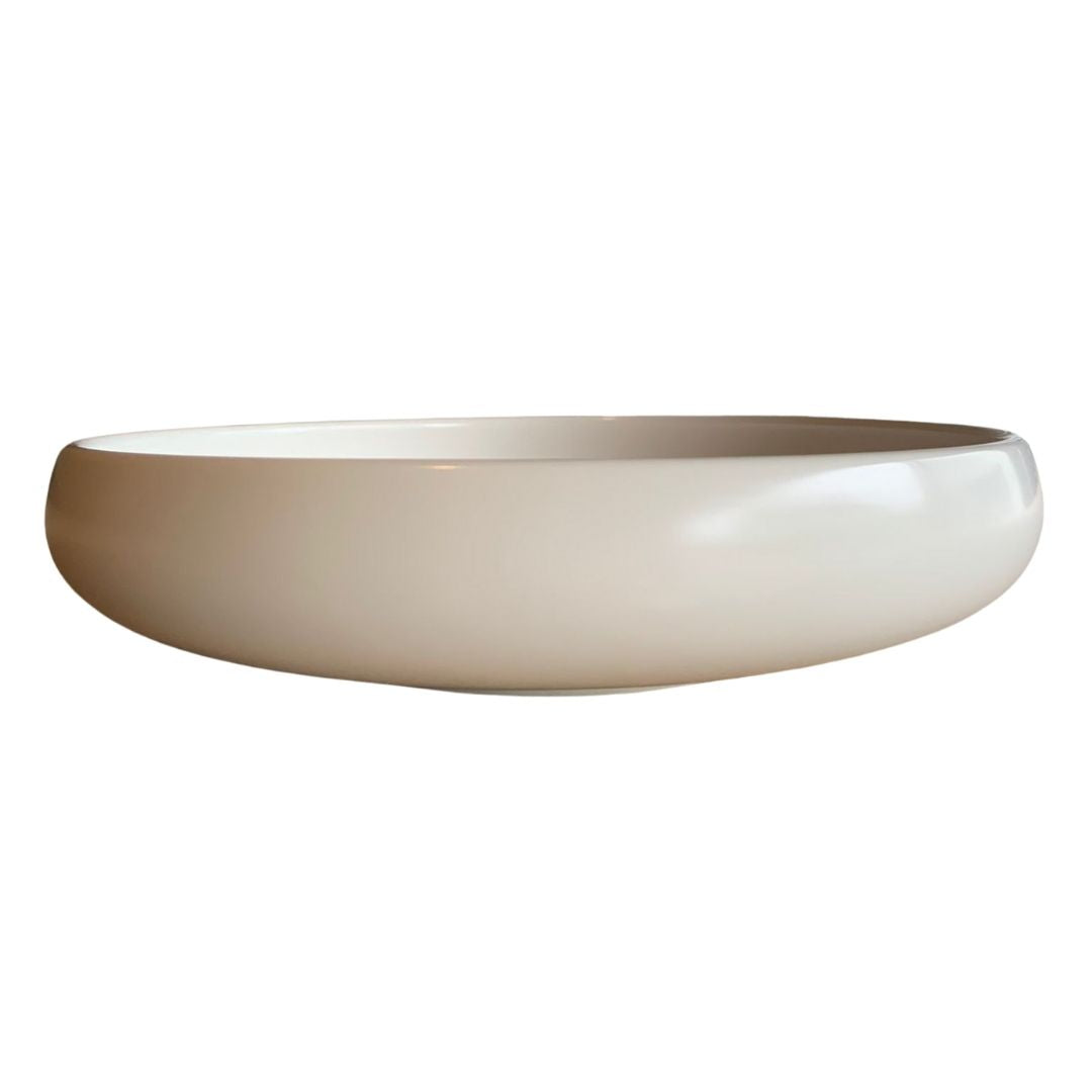 White shallow porcelain bowl side view on a plain white background