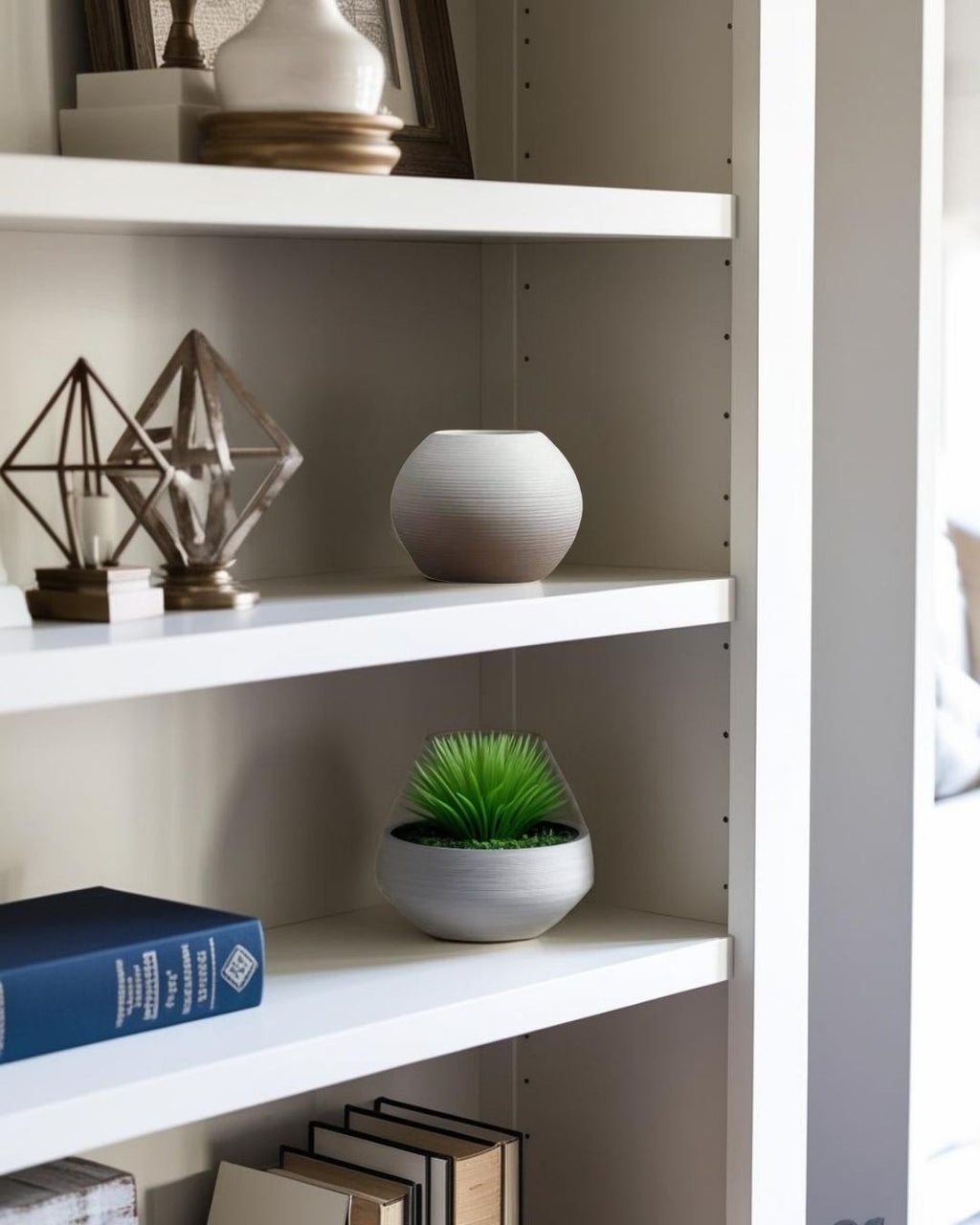 White vase and sculpture on bookcase in a compact Japandi living room in an apartment.